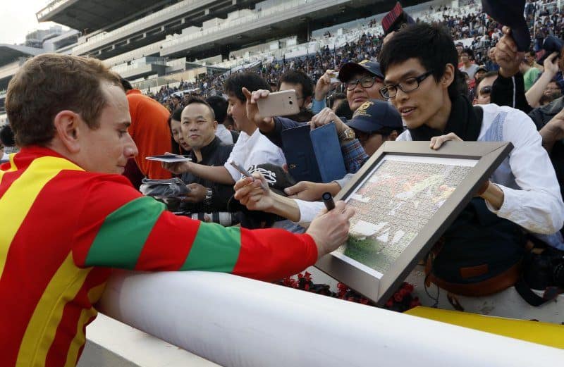 Ryan Moore skriver autografer efter sejren i Hong Kong Cup (Gr.1). Foto: Hong Kong Jockey Club.