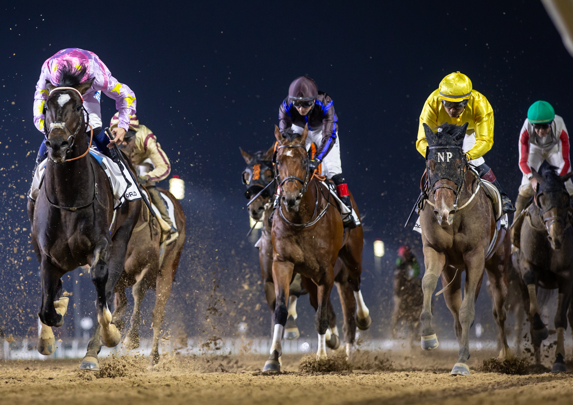 Doc Holliday og Carlos Lopez i de gule farver galopperer over målstregen som sjette i sin debut på Meydan. Foto/Copyright: Erika Rasmussen for GalopSport.